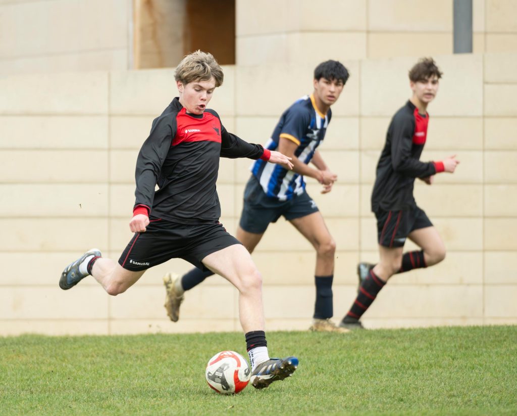 A pupil striking the ball during a football match