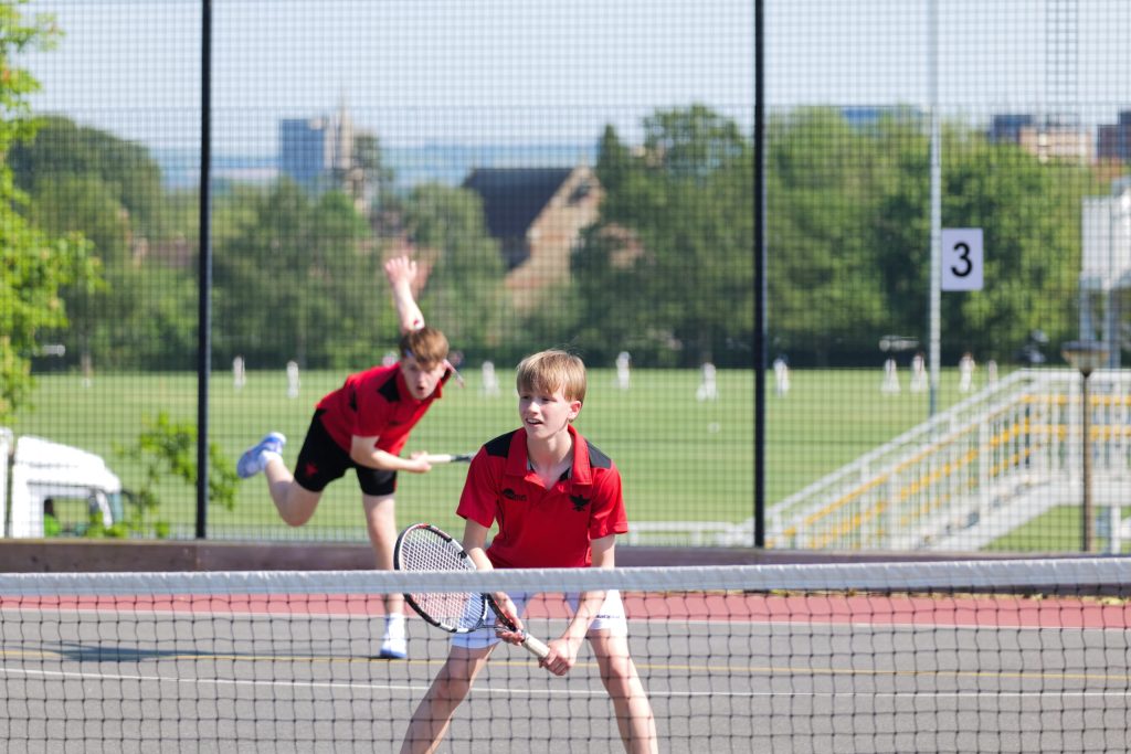 Pupils playing tennis on the school courts